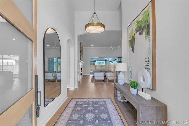 foyer entrance with hardwood / wood-style floors, ceiling fan, and a towering ceiling