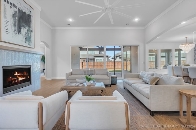 living room featuring hardwood / wood-style flooring, ornamental molding, and a healthy amount of sunlight