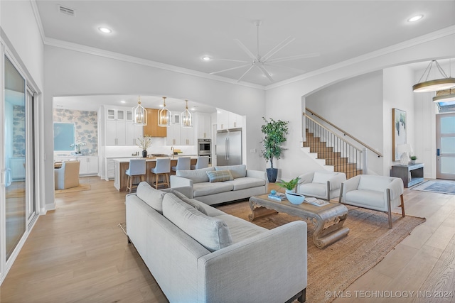 living room with ceiling fan, light hardwood / wood-style flooring, and ornamental molding