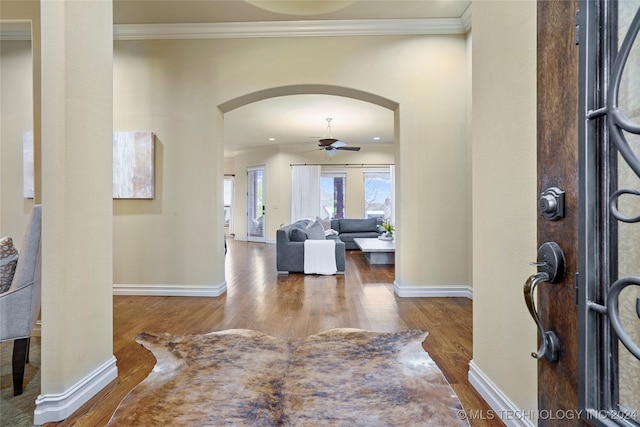 entrance foyer with ornamental molding, wood-type flooring, and ceiling fan