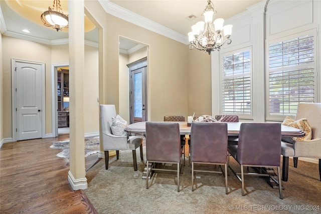 dining space featuring hardwood / wood-style floors, a notable chandelier, and ornamental molding