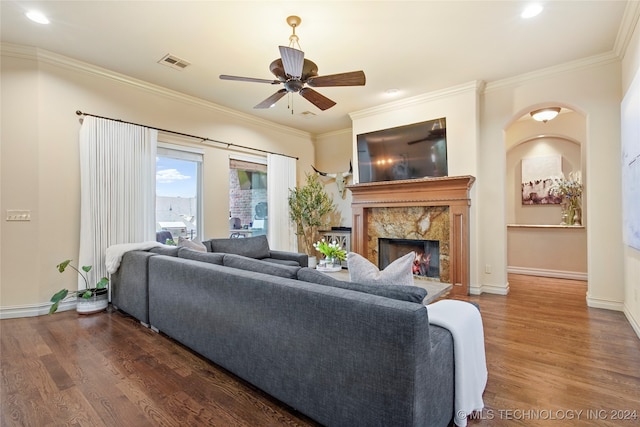 living room with dark hardwood / wood-style flooring, ceiling fan, and ornamental molding