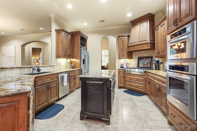 kitchen featuring a kitchen island, backsplash, sink, and stainless steel appliances