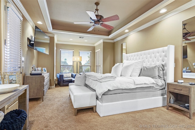 carpeted bedroom with ceiling fan, crown molding, and a tray ceiling