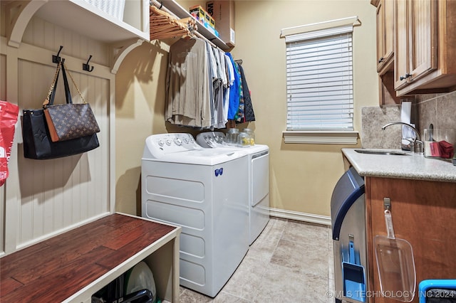 washroom featuring washer and clothes dryer, cabinets, and sink