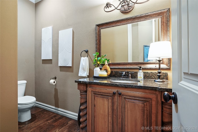 bathroom with hardwood / wood-style floors, vanity, and toilet