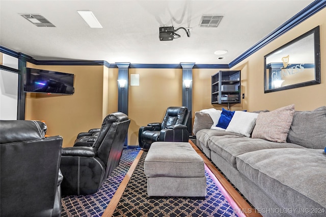 cinema room featuring ornamental molding, dark wood-type flooring, and decorative columns