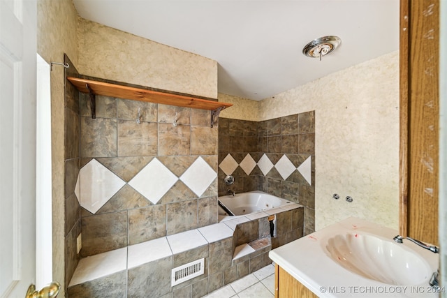 bathroom with vanity, tile patterned flooring, and tiled tub