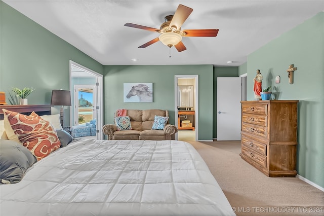 bedroom featuring light colored carpet, ceiling fan, and connected bathroom