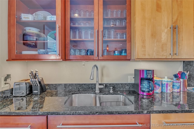 kitchen featuring sink and dark stone countertops