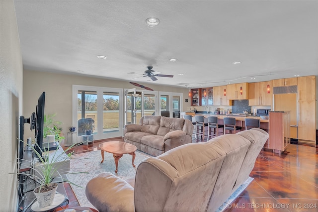 tiled living room featuring ceiling fan and a textured ceiling