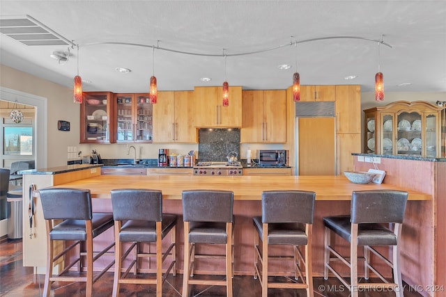 kitchen with decorative backsplash, wooden counters, a breakfast bar area, and stainless steel appliances