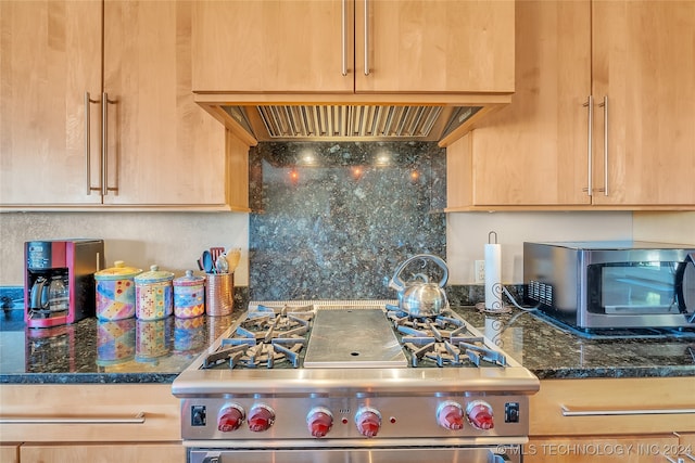 kitchen featuring extractor fan, appliances with stainless steel finishes, light brown cabinets, and dark stone countertops