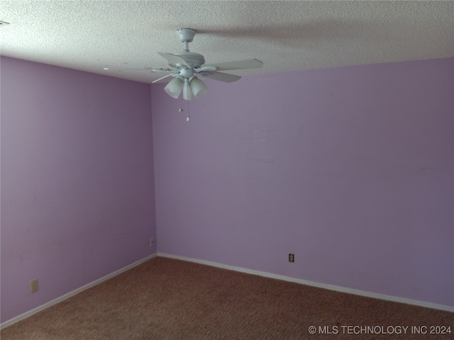 carpeted spare room featuring a textured ceiling and ceiling fan