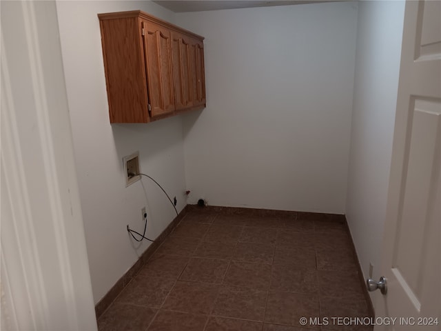 laundry area with cabinets, hookup for a washing machine, and dark tile patterned flooring