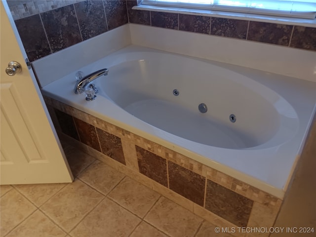 bathroom with tiled bath and tile patterned flooring