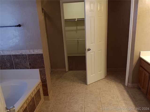 bathroom with vanity, tile patterned floors, and a relaxing tiled tub