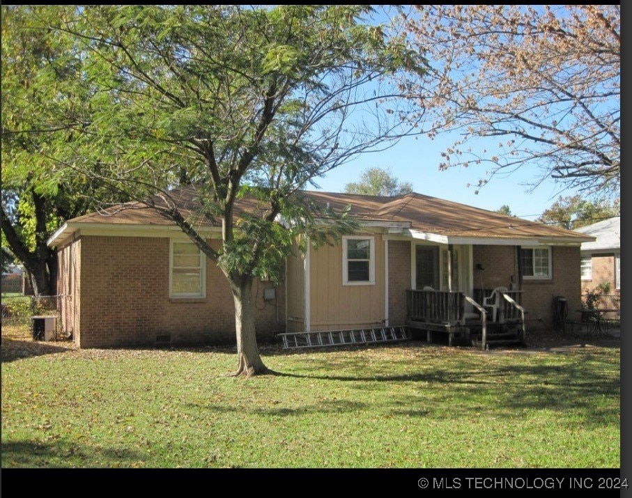 rear view of house featuring central AC and a yard