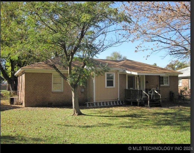 rear view of house featuring central AC and a yard