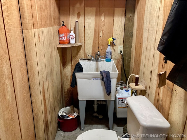 bathroom with sink and wood walls