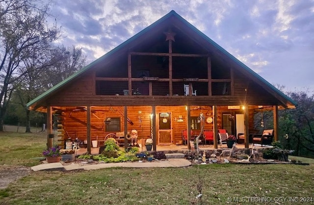 rear view of property featuring a lawn and an outdoor hangout area