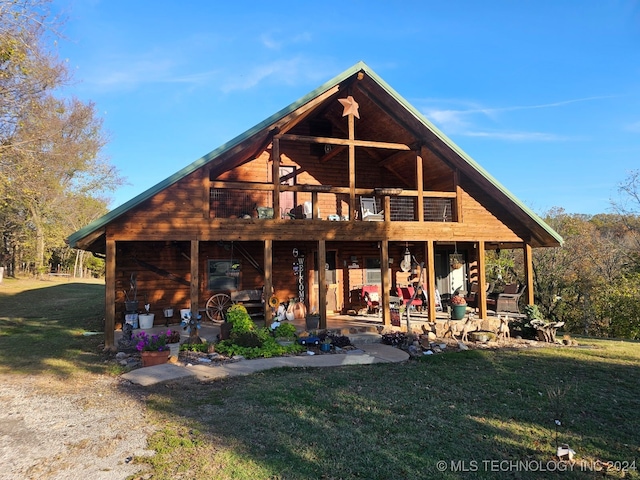 back of property featuring a yard, a deck, and a patio area