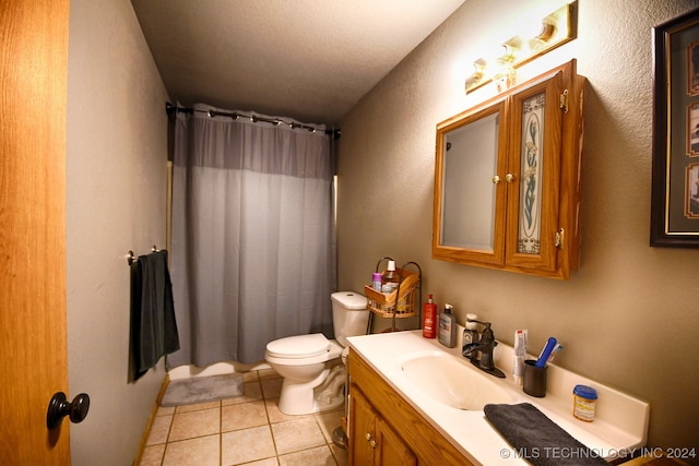 bathroom with vanity, tile patterned flooring, toilet, a textured ceiling, and curtained shower