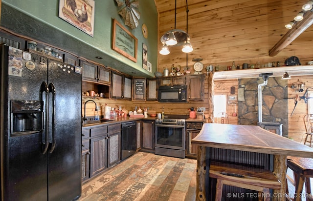 kitchen with wood walls, dark brown cabinets, black appliances, and sink