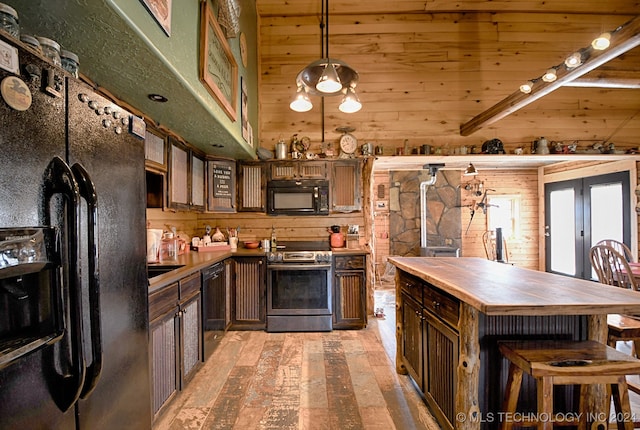 kitchen with wood walls, black appliances, decorative light fixtures, dark brown cabinets, and wood ceiling