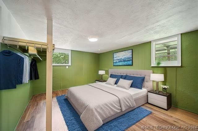 bedroom with light hardwood / wood-style floors and a textured ceiling