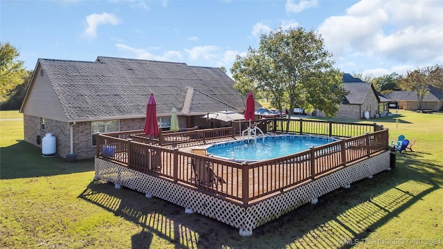 view of swimming pool featuring a deck and a lawn