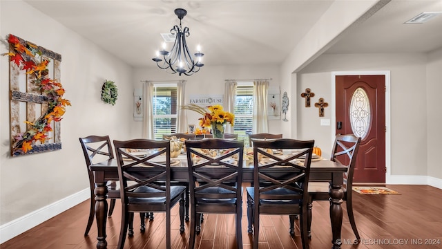 dining room with dark hardwood / wood-style floors and a notable chandelier