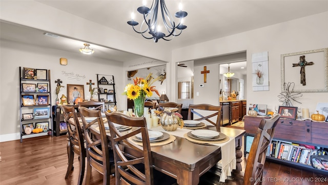 dining space featuring dark wood-type flooring and a notable chandelier