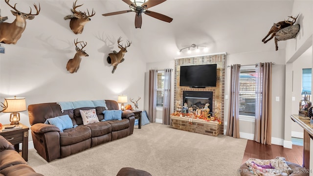 carpeted living room featuring ceiling fan, lofted ceiling, and a fireplace