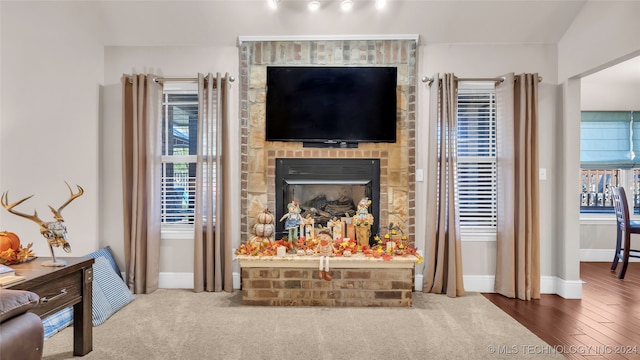 living room with wood-type flooring and a brick fireplace