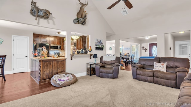 living room featuring dark wood-type flooring, high vaulted ceiling, and ceiling fan