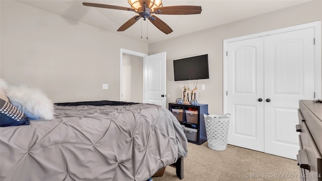 bedroom featuring light carpet, ceiling fan, and a closet