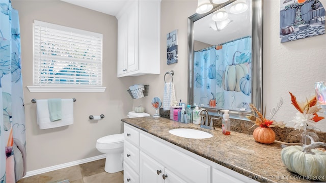 bathroom with vanity, tile patterned flooring, toilet, and walk in shower