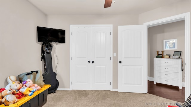 carpeted bedroom featuring ceiling fan and a closet