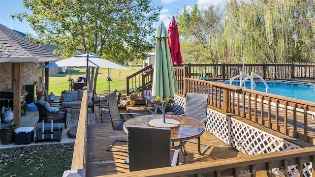 deck with an outdoor living space and a fenced in pool