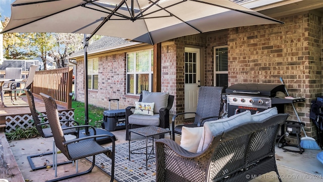 view of patio with an outdoor living space, a wooden deck, and area for grilling