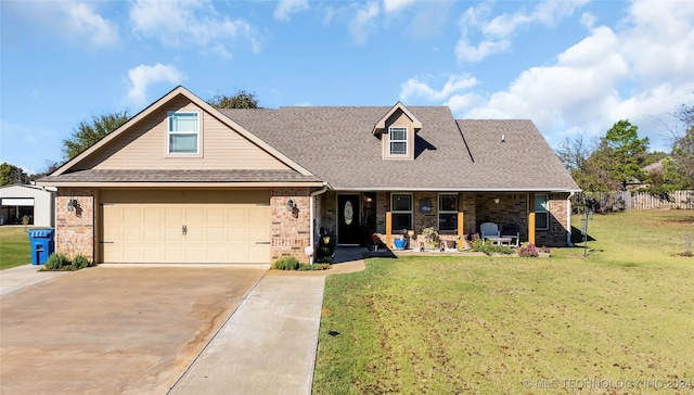 view of front of property featuring a garage, a front yard, and covered porch