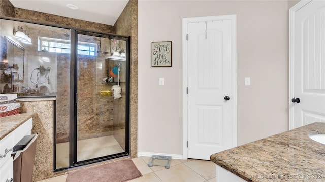 bathroom featuring tile patterned flooring, vanity, and an enclosed shower