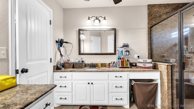 bathroom featuring vanity, a shower with shower door, and ceiling fan