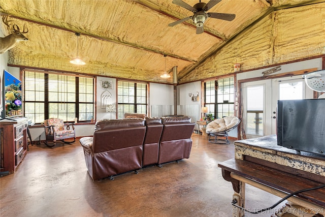 living room featuring plenty of natural light, lofted ceiling, ceiling fan, and concrete floors