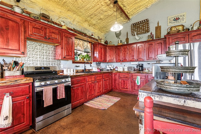 kitchen featuring lofted ceiling, sink, dark carpet, stainless steel stove, and pendant lighting