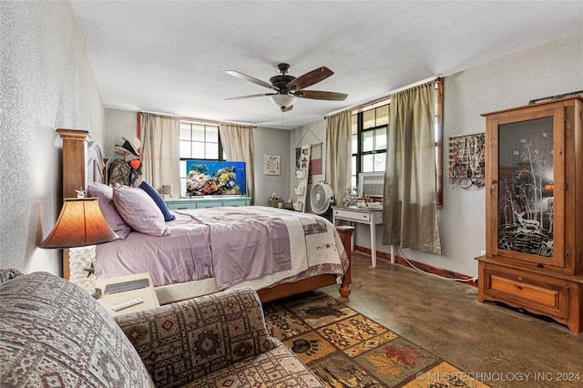 carpeted bedroom featuring ceiling fan, multiple windows, and a textured ceiling