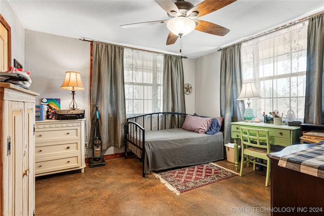 bedroom featuring ceiling fan, multiple windows, and dark colored carpet