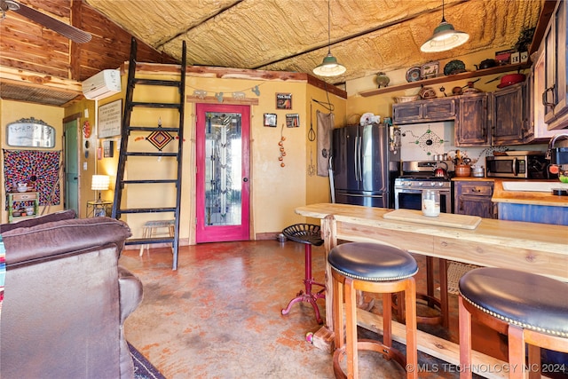 kitchen with concrete floors, a wall mounted AC, stainless steel appliances, butcher block counters, and hanging light fixtures