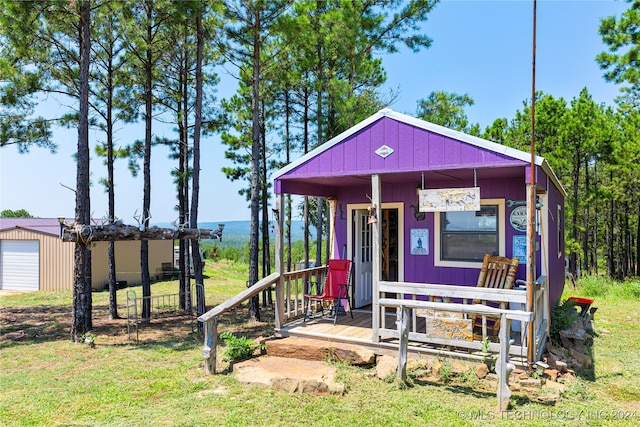 view of front of home featuring a garage, an outdoor structure, and a front lawn